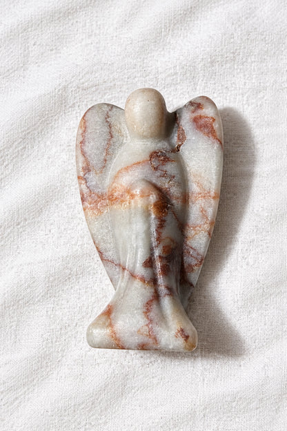 Red Vein Jasper carved angel with wings resting on a white background