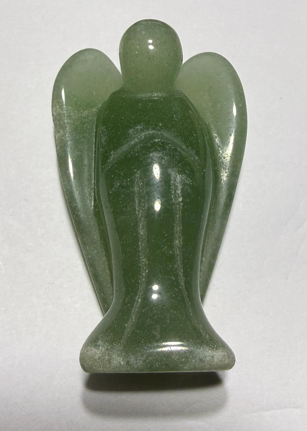 Green Aventurine hand carved angel with wings, resting on a white background