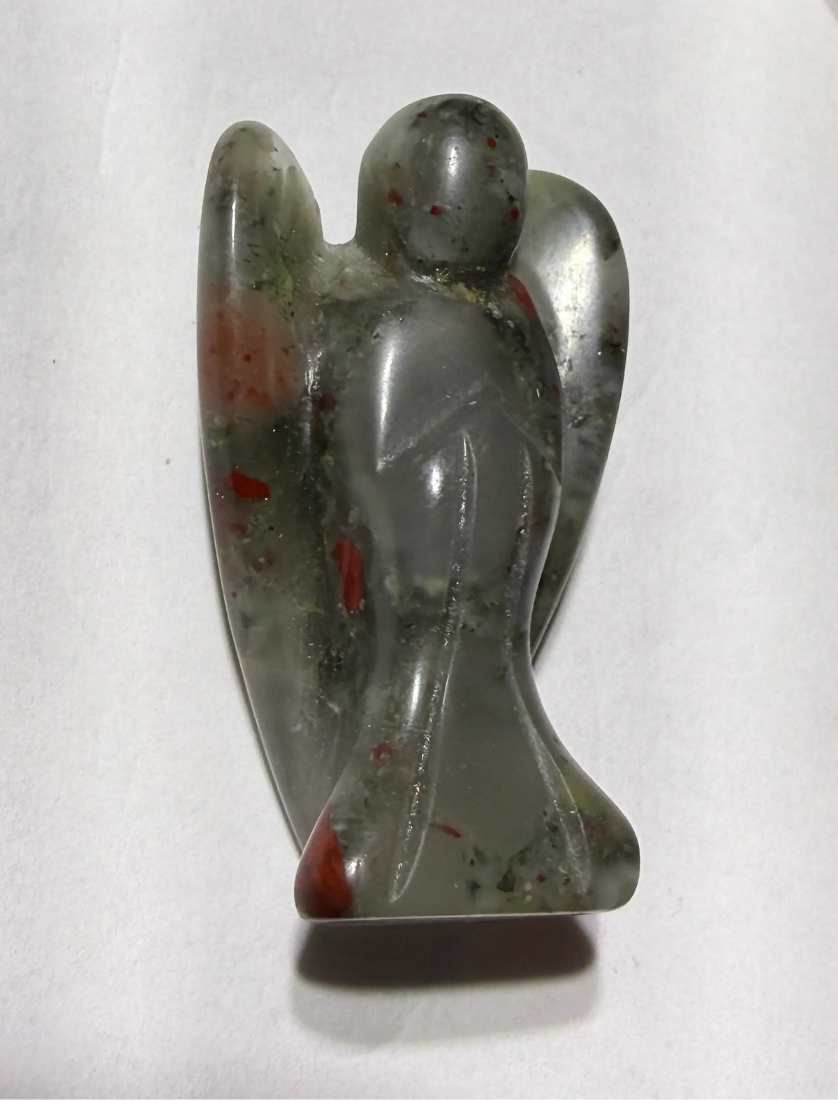 side view of small angel figurine carved from bloodstone crystal