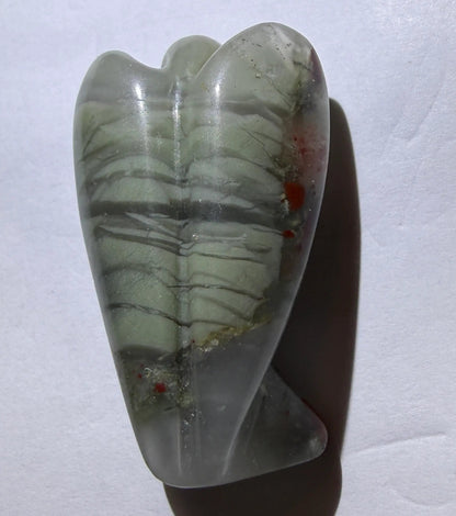 close up view of back hand carved angel using bloodstone crystal 