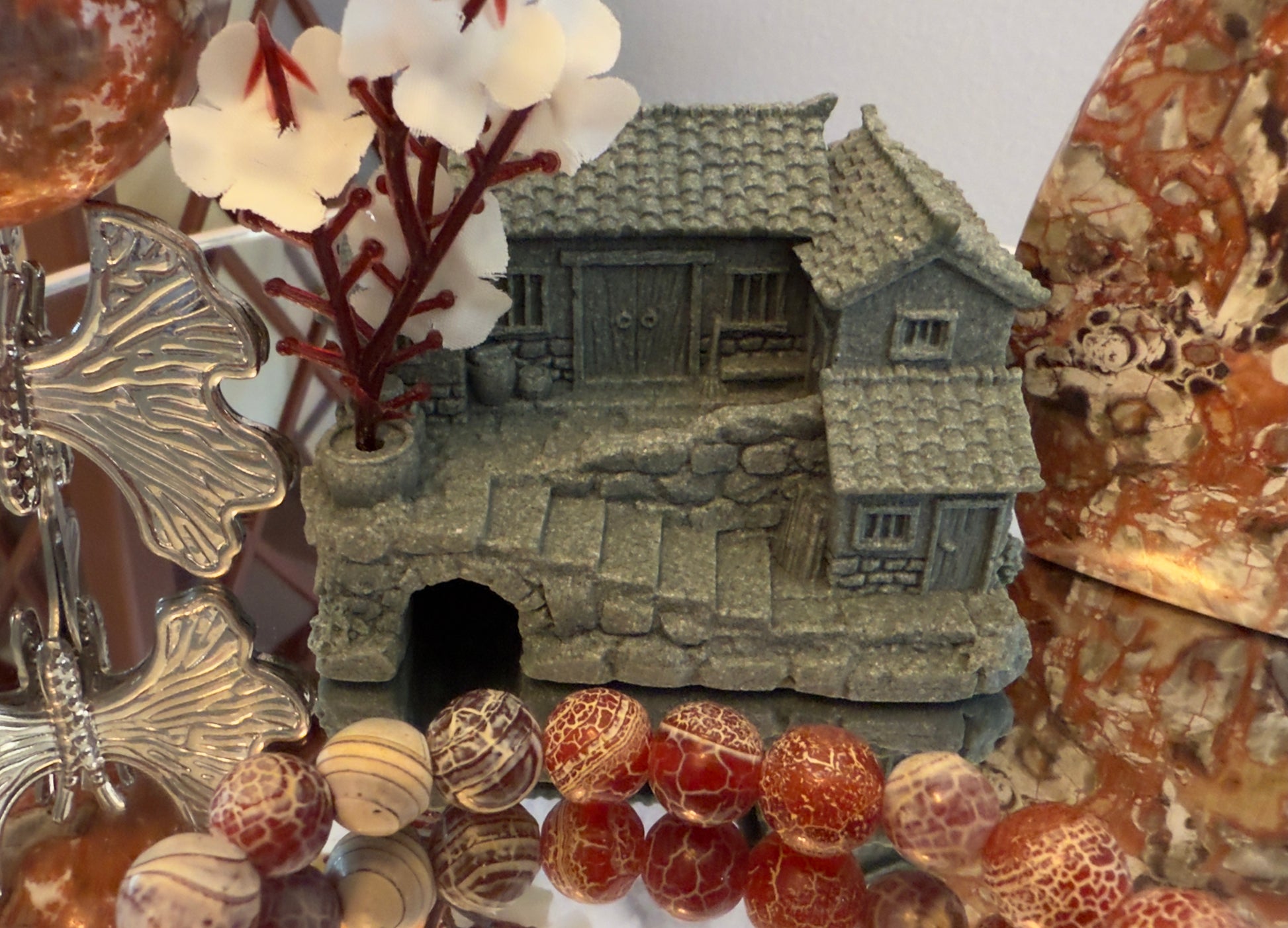 Sandstone crystal house and butterfly stand displaying natural earth tones for grounding and spiritual protection