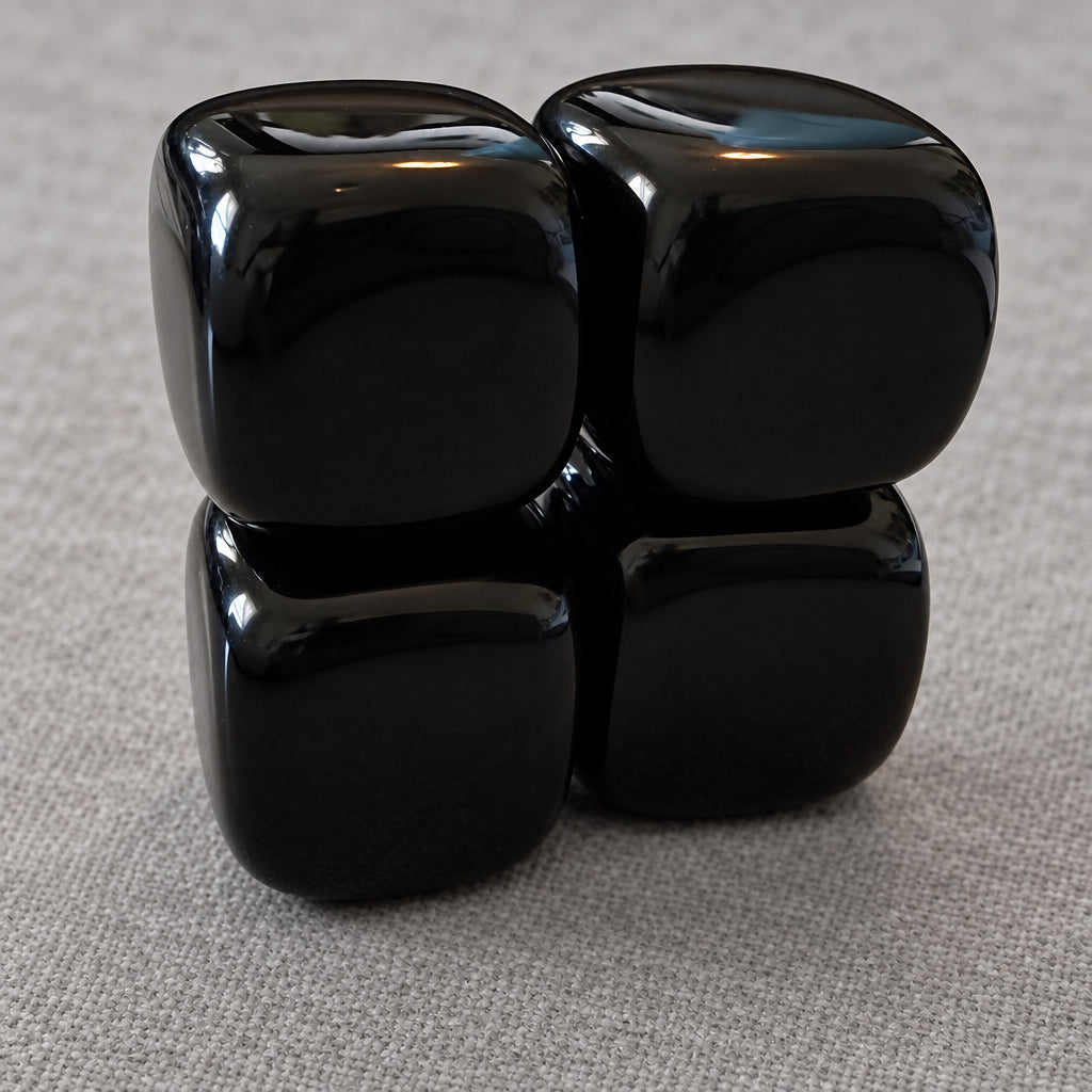 close up photo four black agate carved crystal cubes