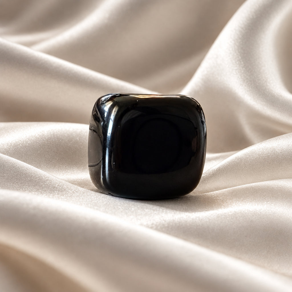close up photo black agate carved crystal cube with a white background