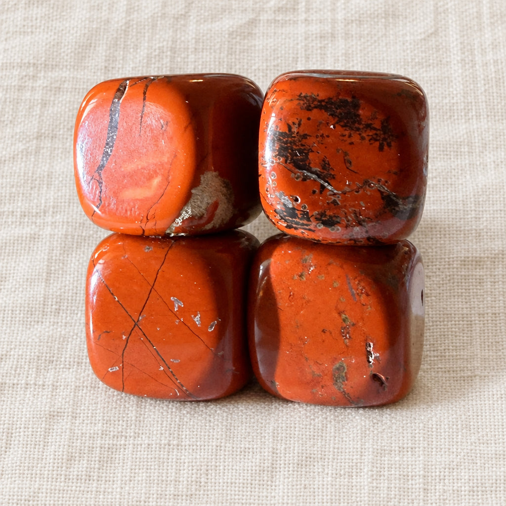 Four brecciated jasper carved crystal cubes on a white background