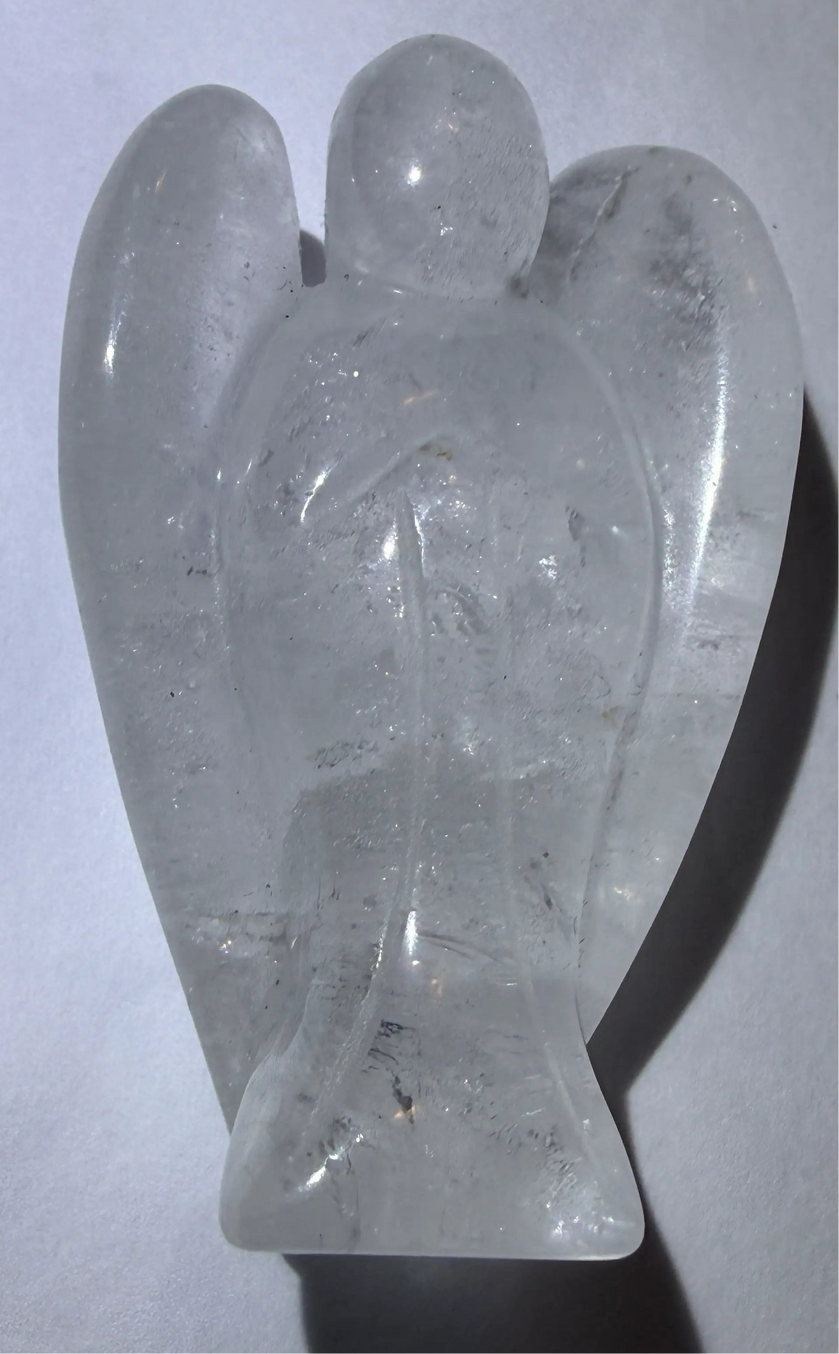 photo of clear quartz carved angel showing rutile, iron oxide inclusions and natural iridescence