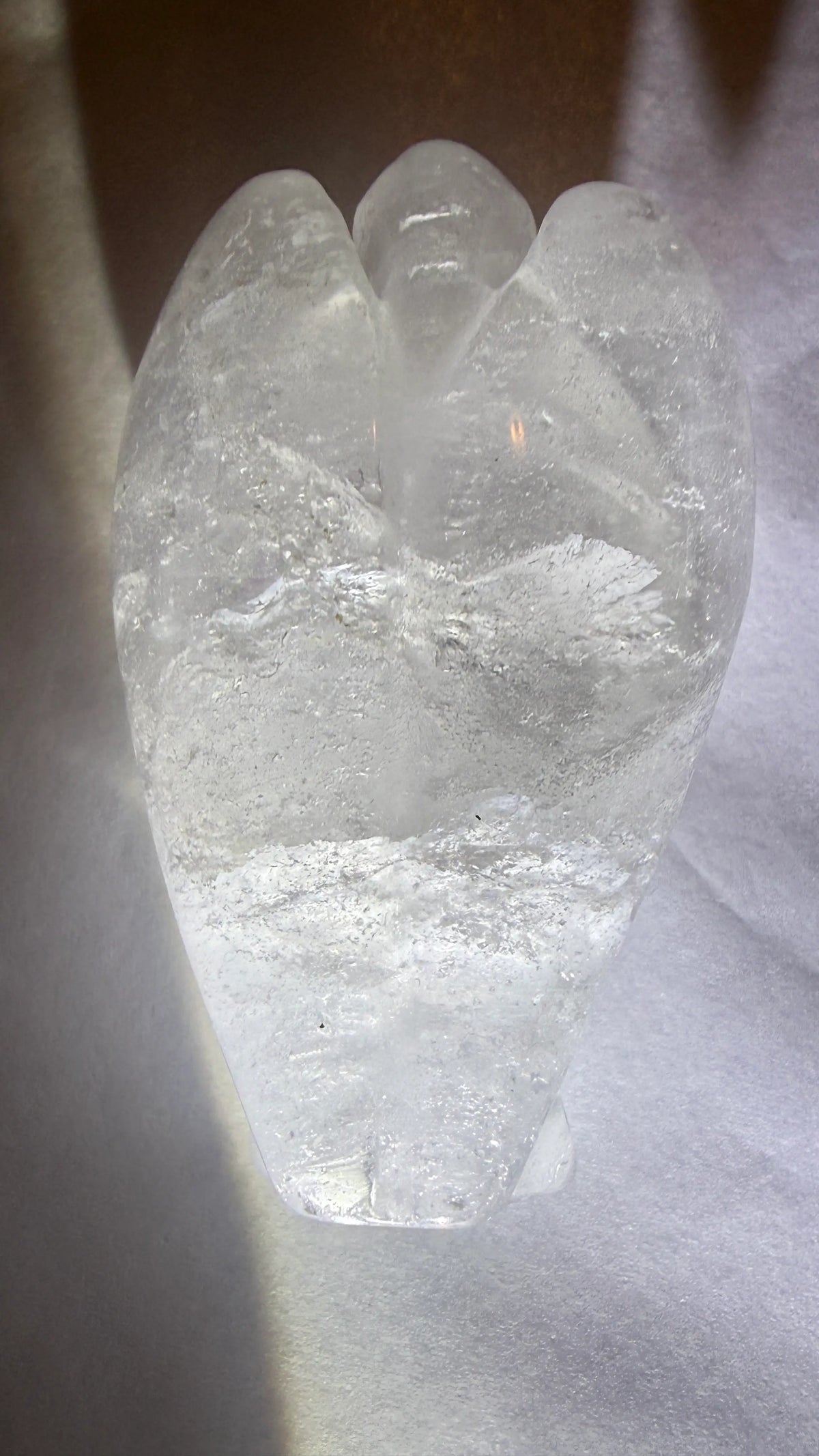 photo of back of clear quartz hand carved angel showing phantom layers