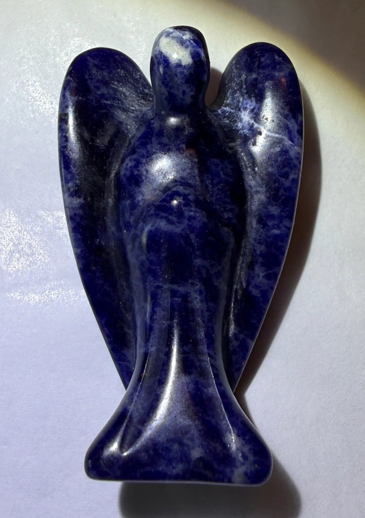 photo sodalite hand carved angelic figurine Deep blues and white streaks characteristic of natural sodalite mineral