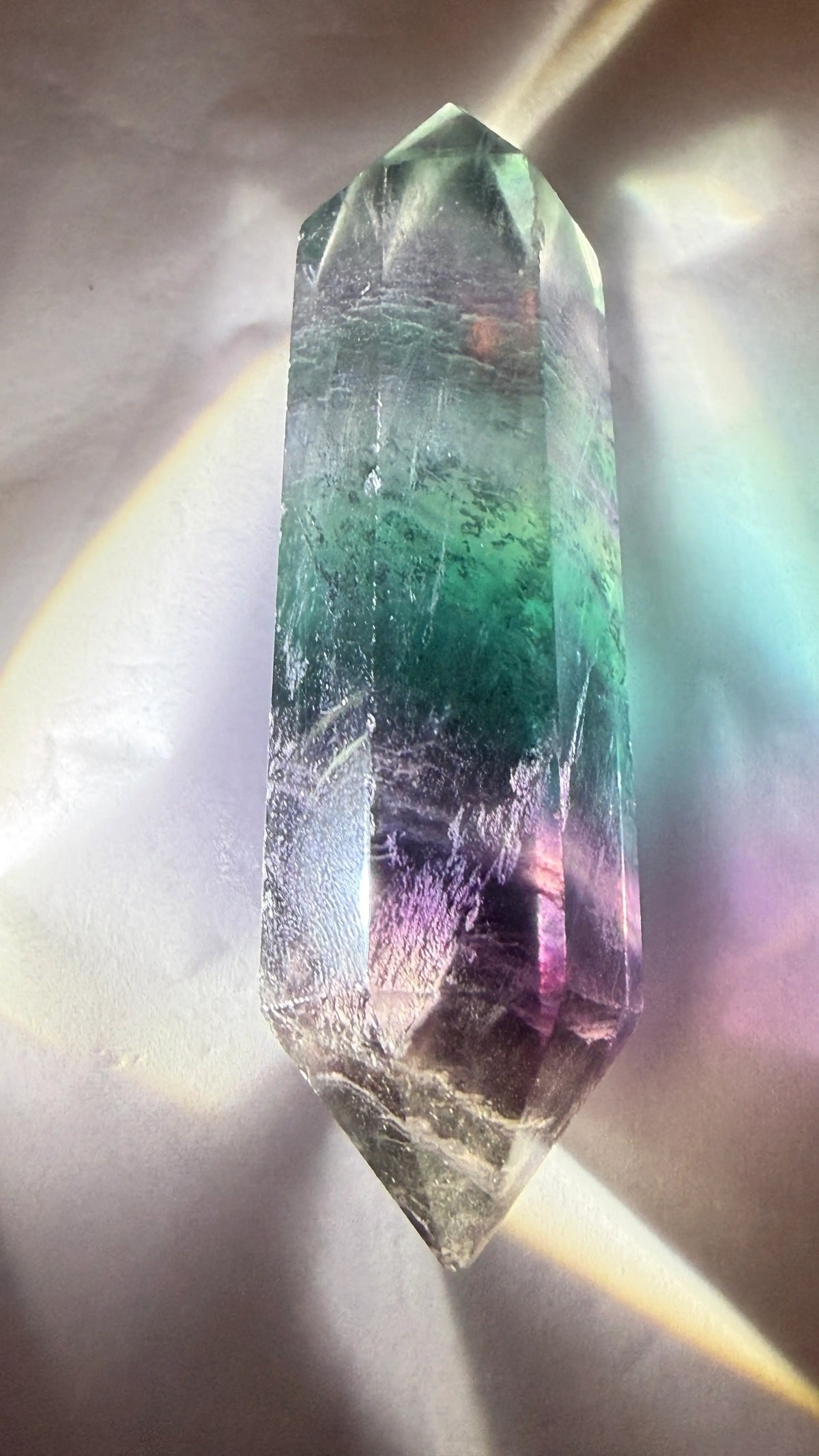 Natural rainbow fluorite double point on a white background
