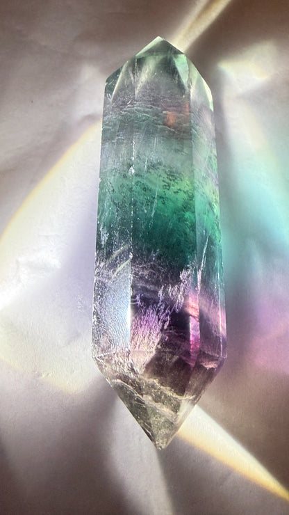 Natural rainbow fluorite double point on a white background