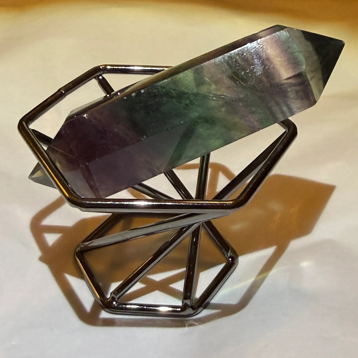 close up other side rainbow fluorite double point in a stand