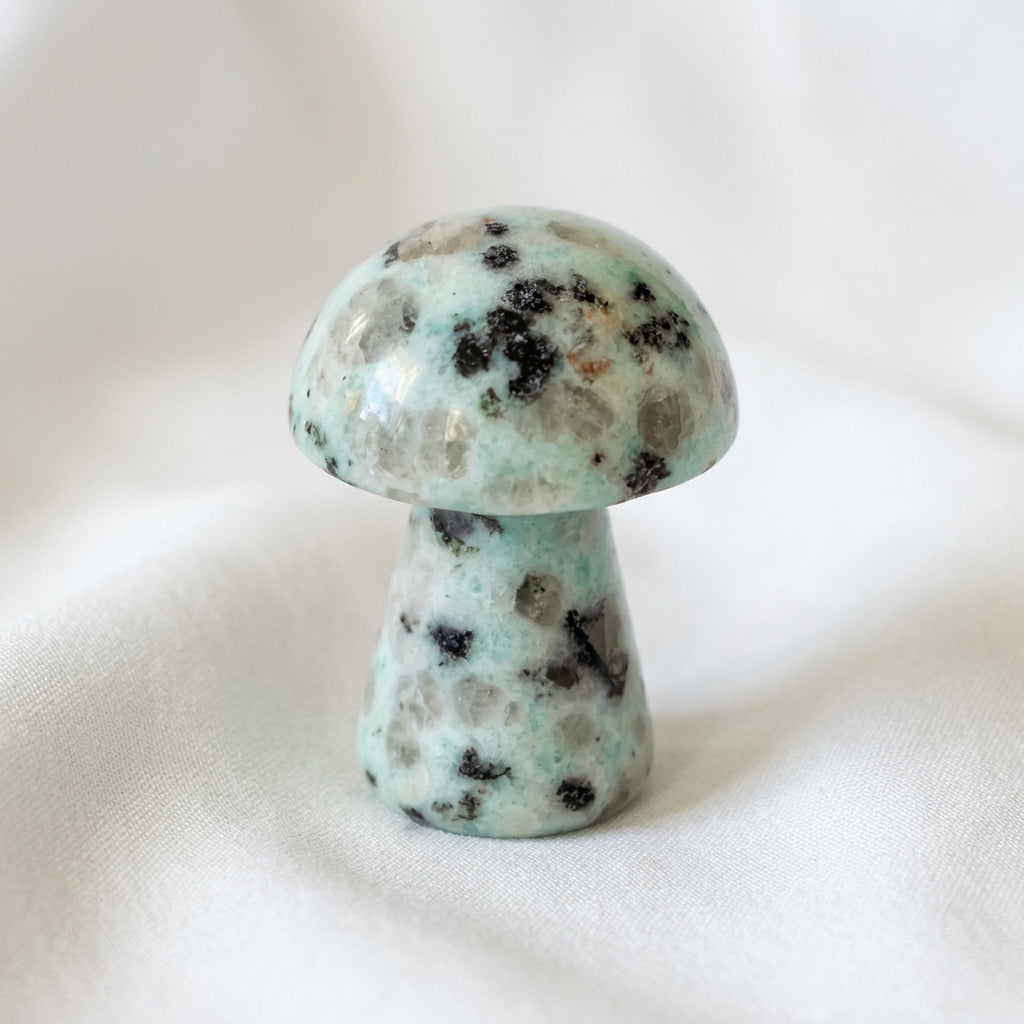 close up of a hand carved mushroom, made from kiwi jasper crystal