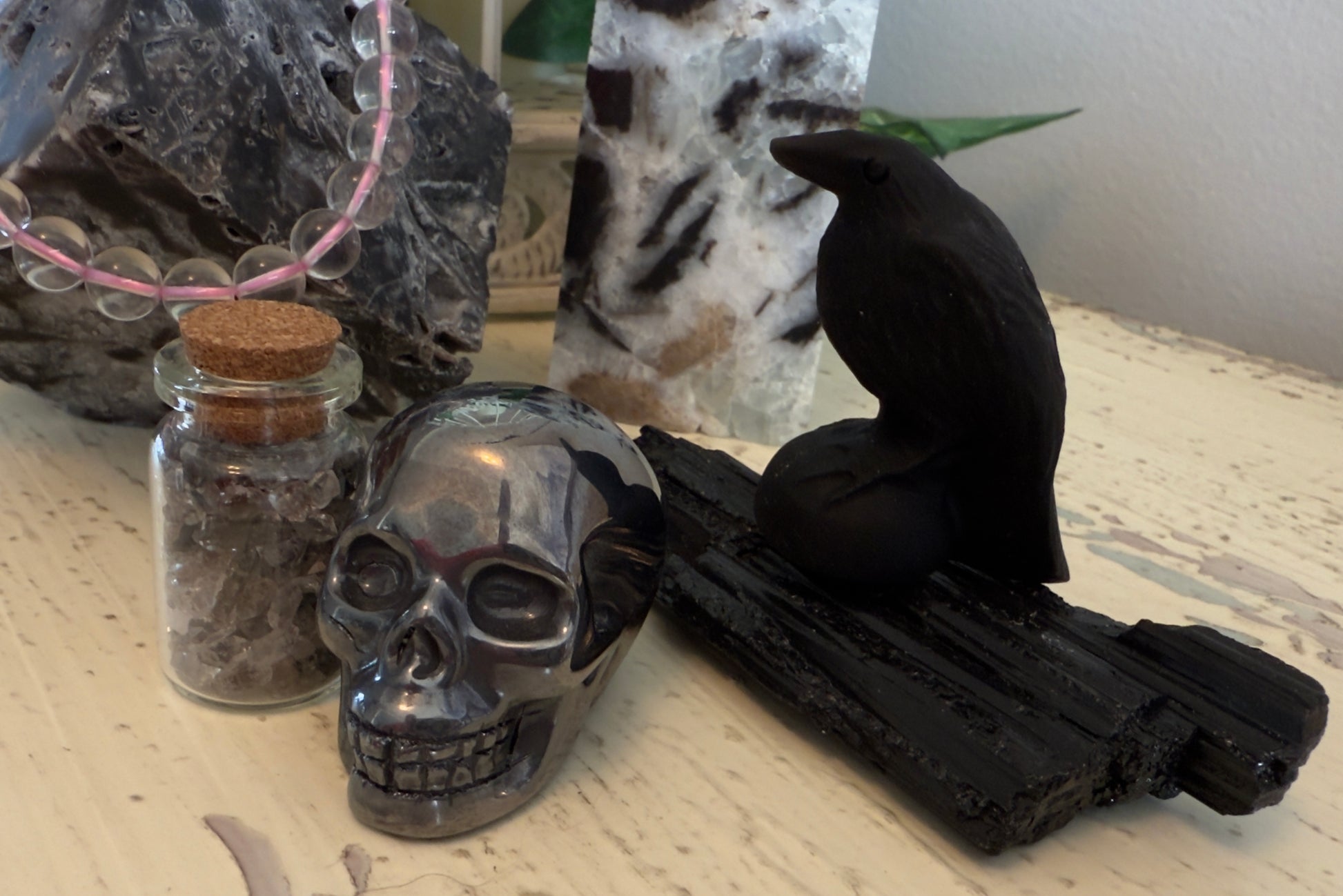 Close up of hematite skull Black tourmaline black obsidian raven and black tourmaline specimen