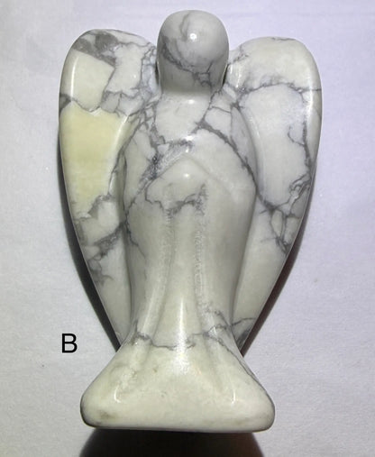 close up front view of angel B carved from howlite. natural sunny yellow iron oxide inclusions