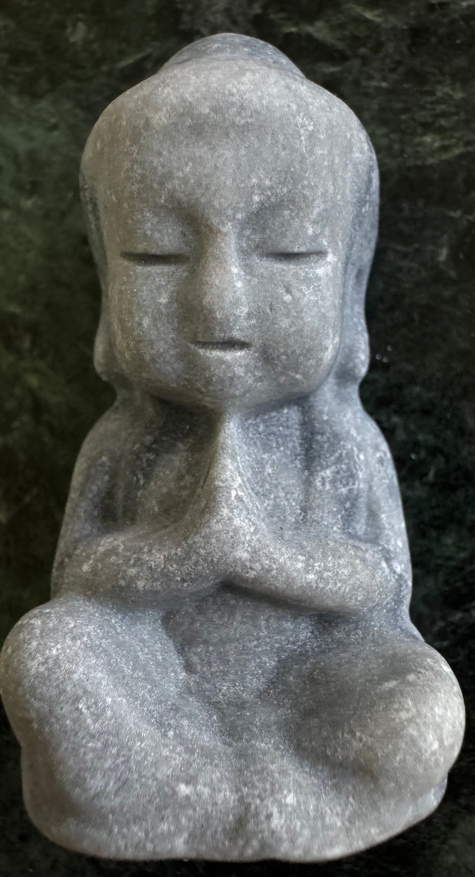 Stone Buddha statue in seated meditation pose.
