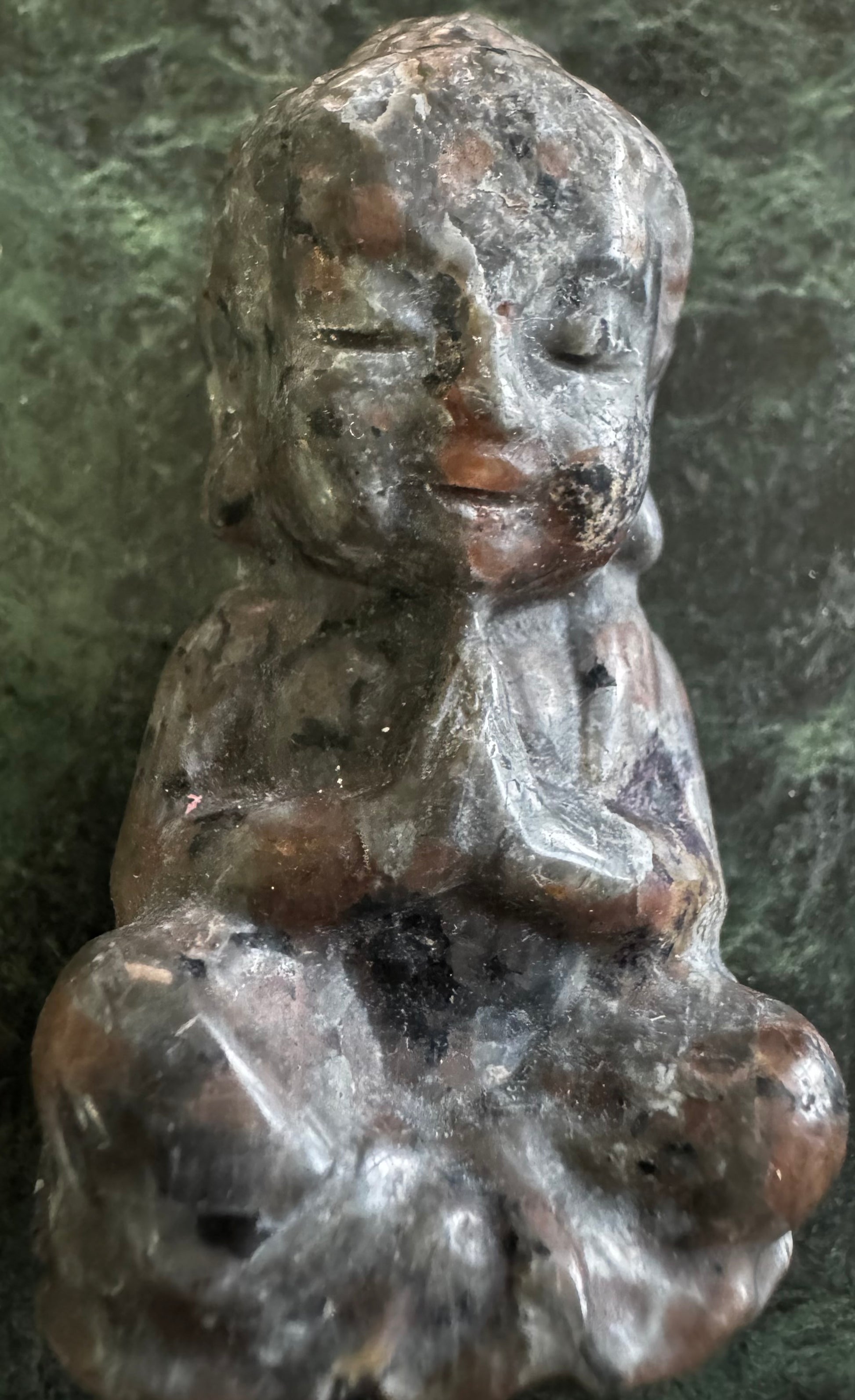 Stone Buddha statue in seated meditative pose.