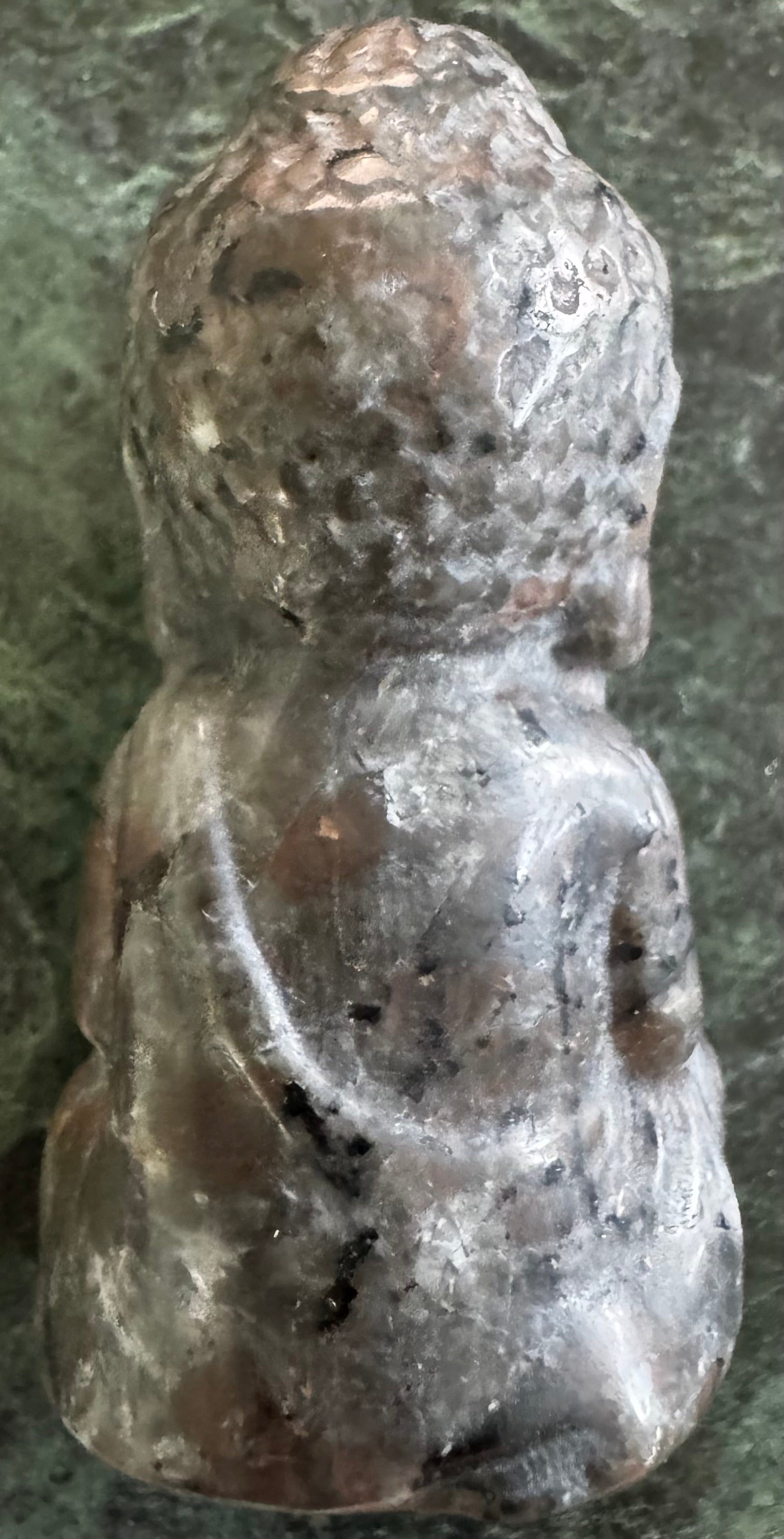 Back view of a gray stone Buddha statue.