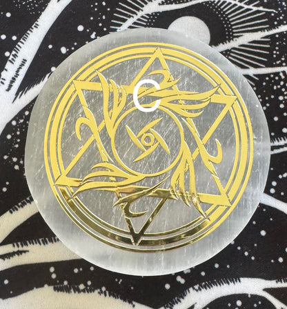 Round selenite disk with gold design.