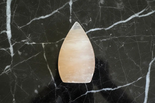 Peach Selenite Freeform on a marble table