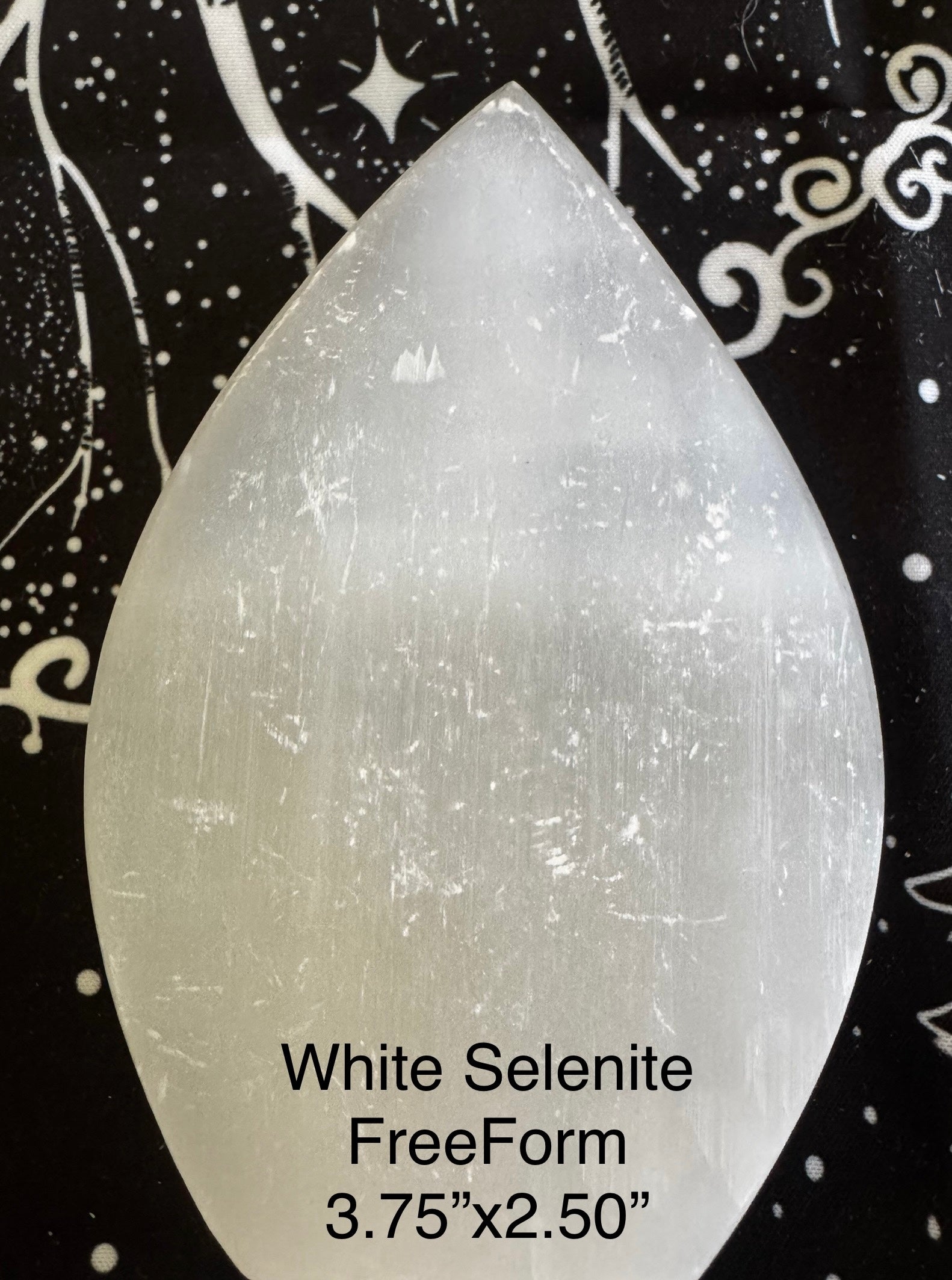White selenite freeform crystal on patterned background.