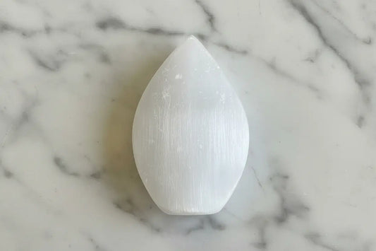 White selenite freeform crystal on patterned background.