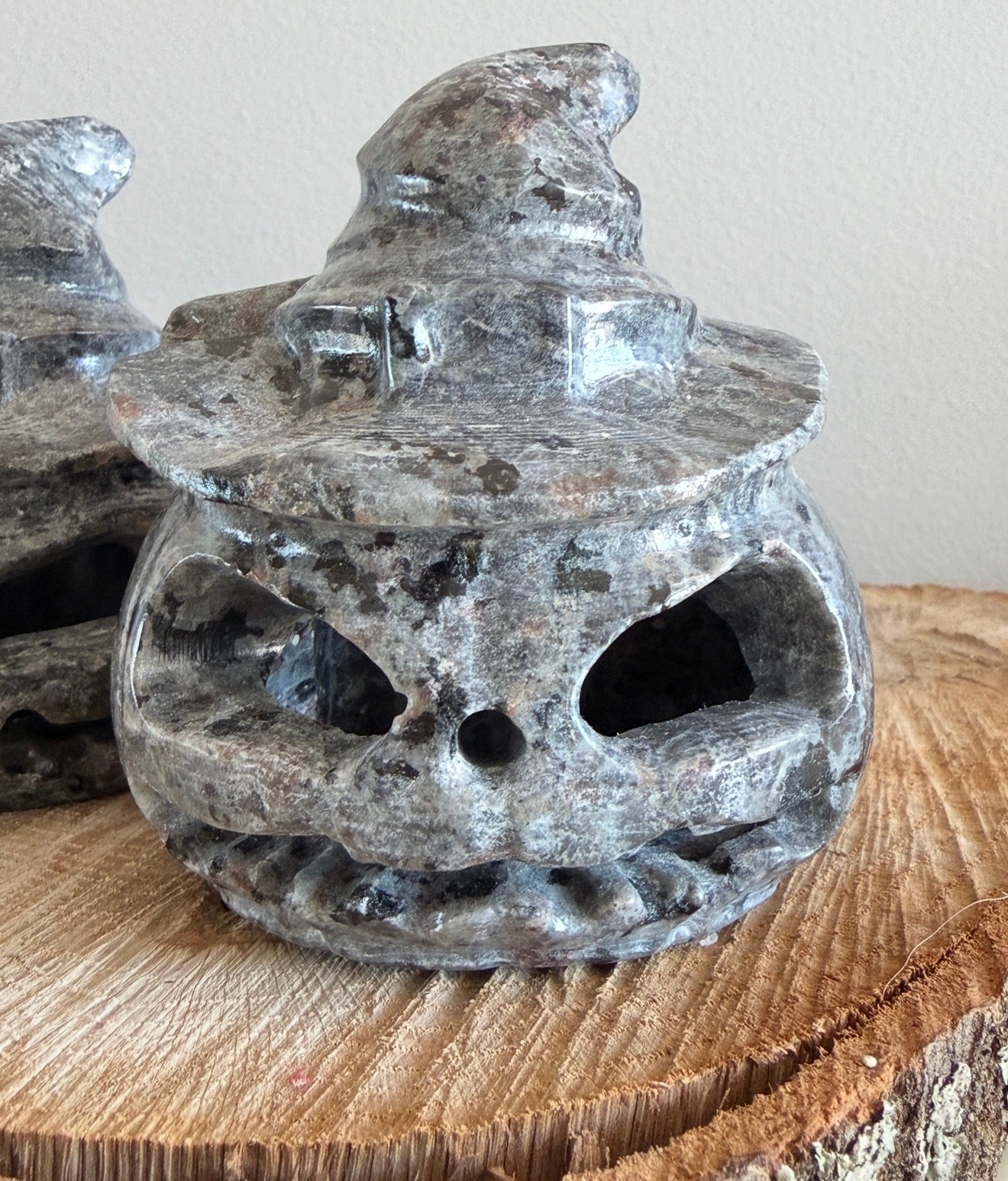 Close up of a Yooperlite Crystal carved into a Jack O’Lantern sitting on a wood slab