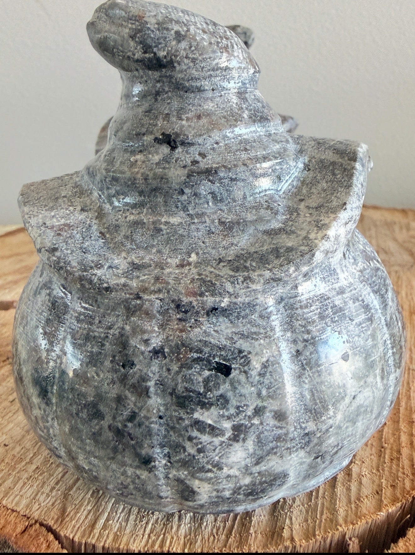 Close up of a Yooperlite Crystal carved into a Jack O’Lantern sitting on a wood slab