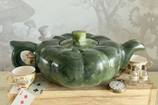 Natural Jade Teapot, sitting on a wooden table with reference to Alice In Wonderland decorations