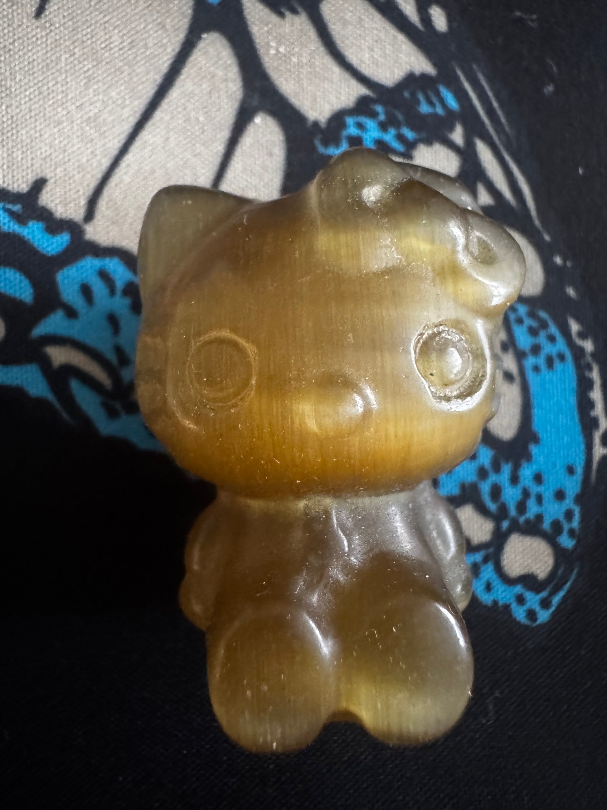Shiny, translucent yellow Hello Kitty figurine.