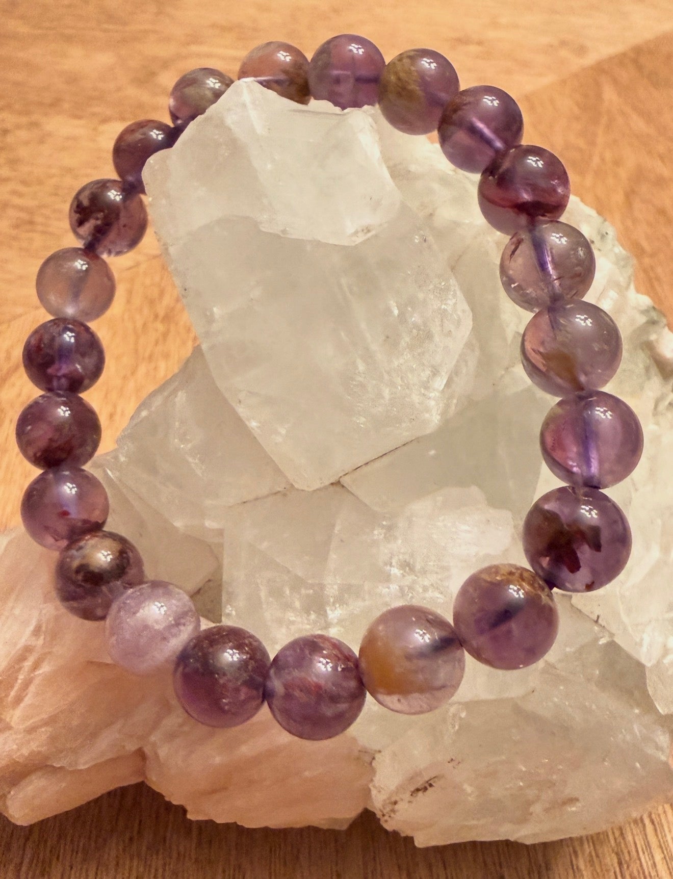 Super 7 Crystal Bead Bracelet displayed on a cluster of crystals