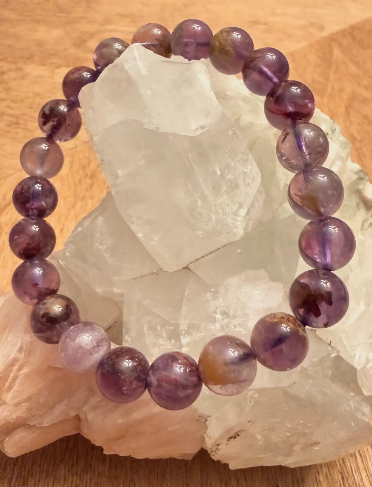 Super 7 Crystal Bead Bracelet displayed on a cluster of crystals