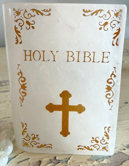 Close up of Quartz slab carved into the shape of a book with gold text Holy Bible and a gold cross 