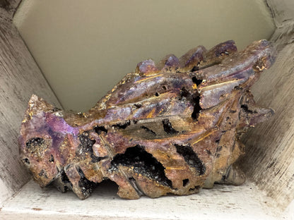 Amethyst and pyrite crystal formation in a decorative wooden box.