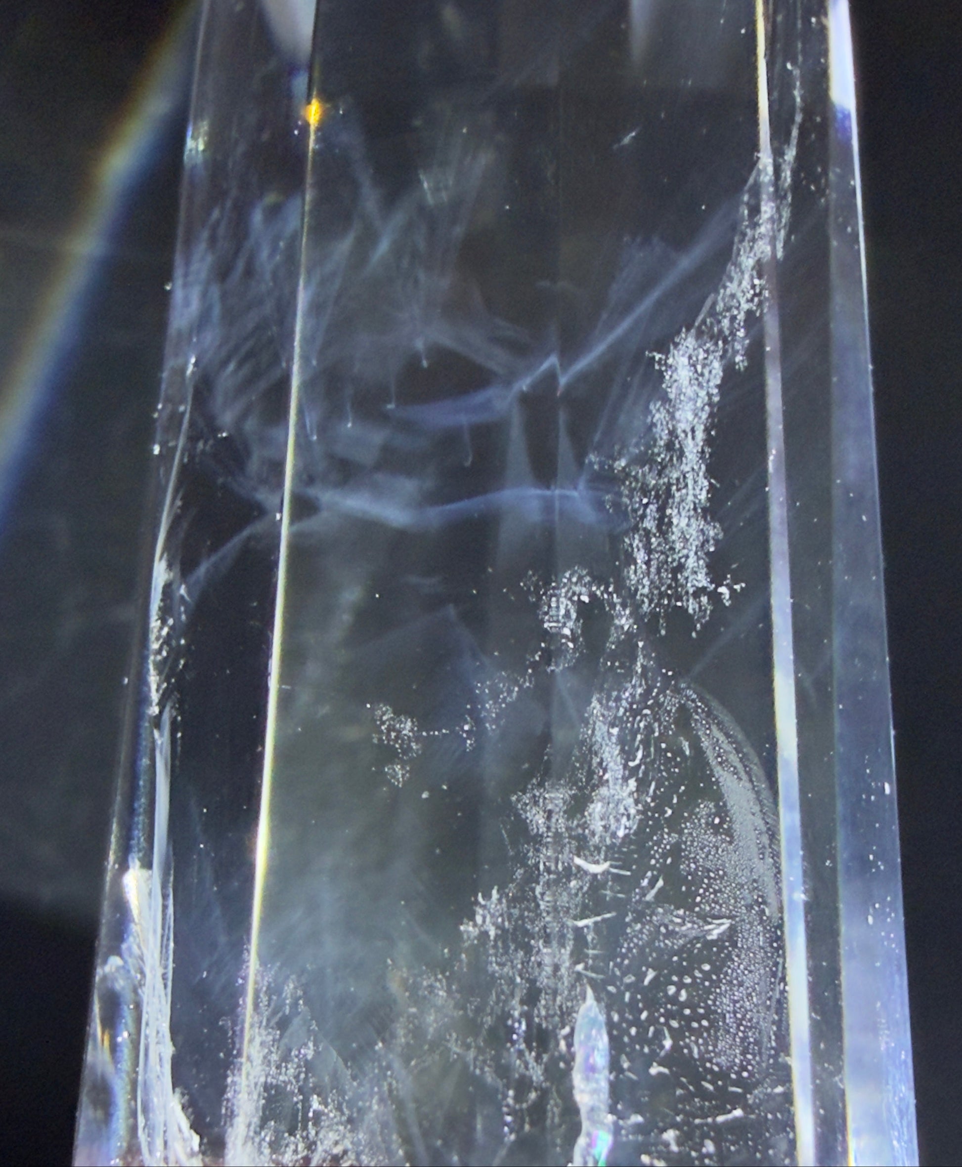 Close up of a clear quartz double terminated point with blue tyndall 