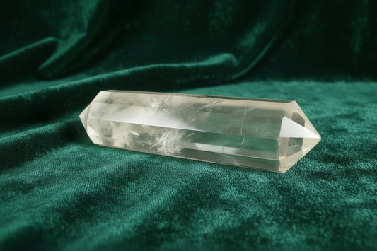 Clear Quartz Double Point with Blue Needle Inclusion sitting on a dark green velvet cloth 
