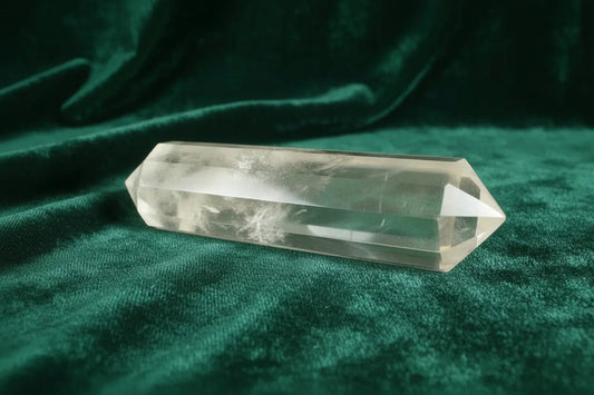 Clear Quartz Double Point with Blue Needle Inclusion sitting on a dark green velvet cloth
