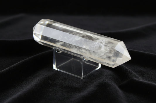 Clear Quartz double point highlighting the high quality of the quartz and Blue Tyndall inclusions on a stand on a table with black velvet as the background