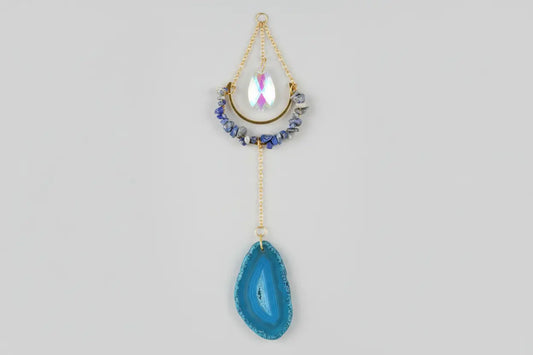 Sodalite suncatcher with blue agate on a plain background
