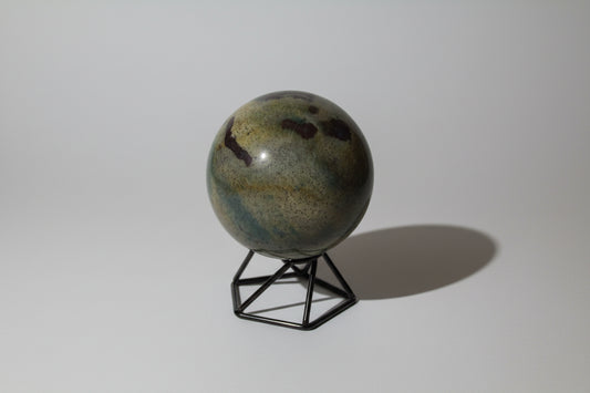 polychrome jasper sphere light green and yellows with some dark brown and tiny spots on a stand with no background  