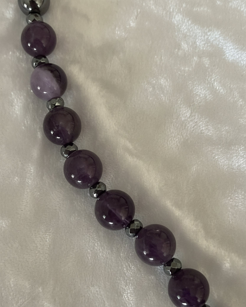 Close up view of amethyst, hematite and black obsidian beads