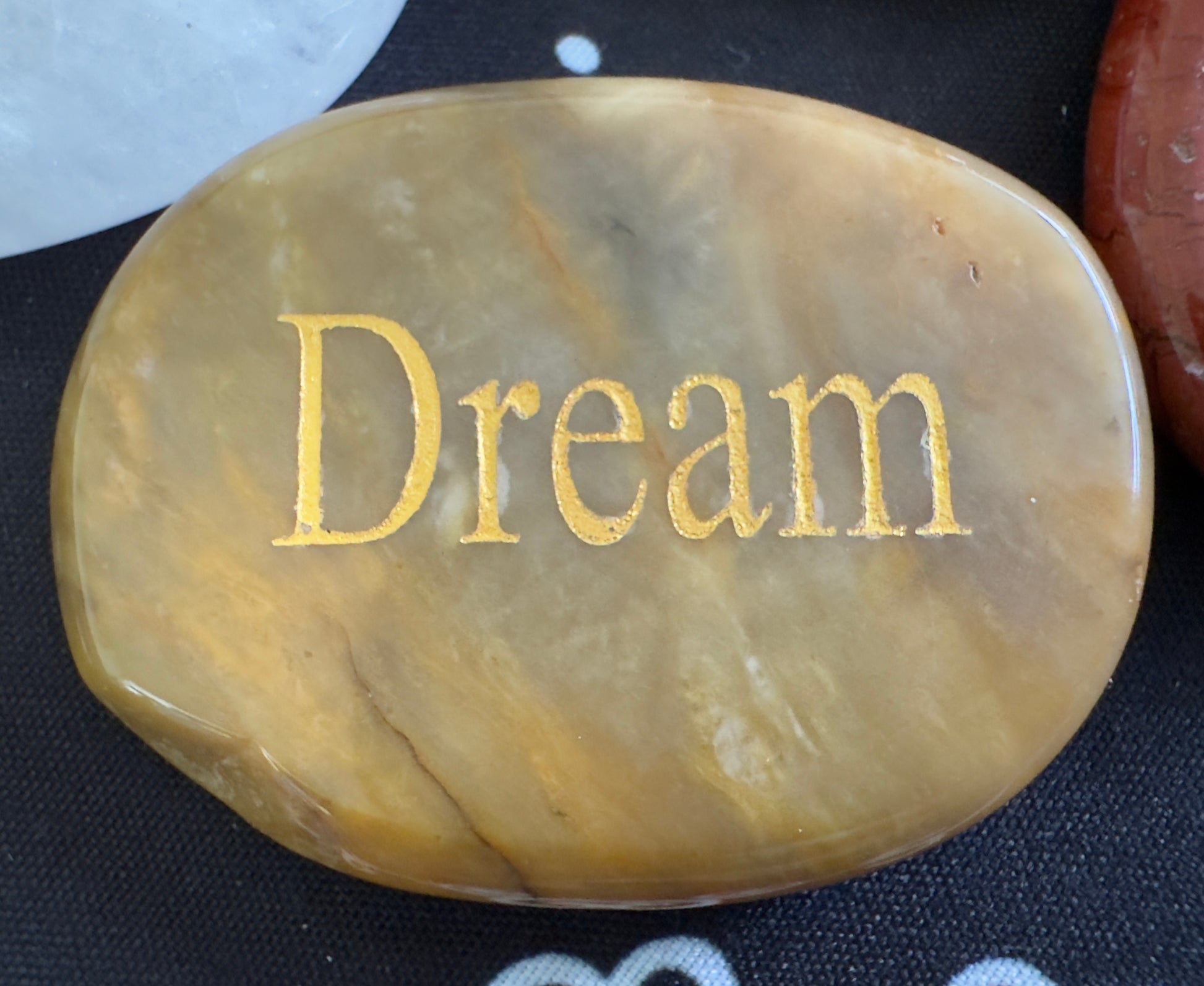 Oval stone with "Dream" in gold text.