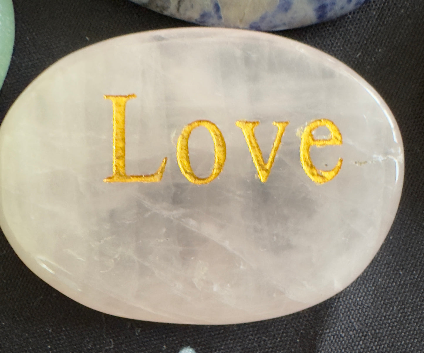 Oval pink crystal with "Love" inscribed in gold lettering.
