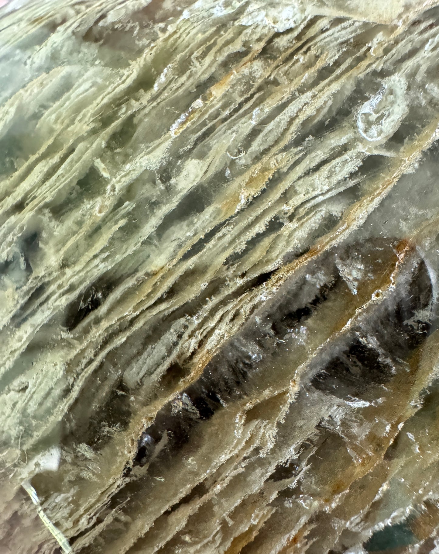 Close-up of a light-colored, striated mineral.