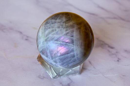 Gray and purple Labradorite sphere protection crystal on marble