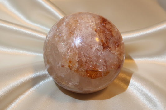 Golden Healer crystal sphere with a cream satin fabric background