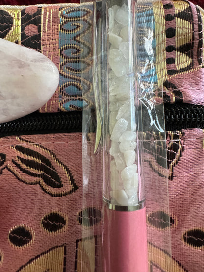 Pink patterned case, rose quartz stone, and a clear tube filled with small white crystals.

