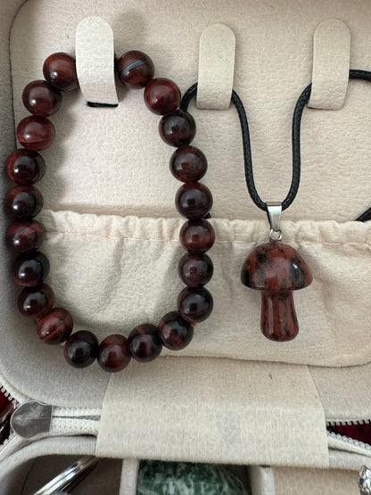 Red-brown beaded bracelet and mushroom pendant in a jewelry case.