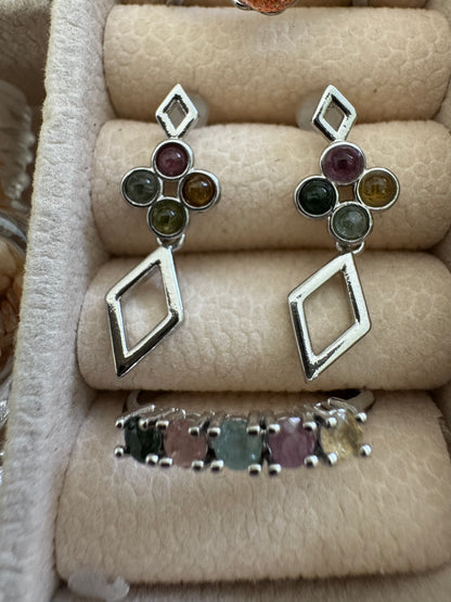 Silver earrings and ring with colorful gemstones in a velvet jewelry box.