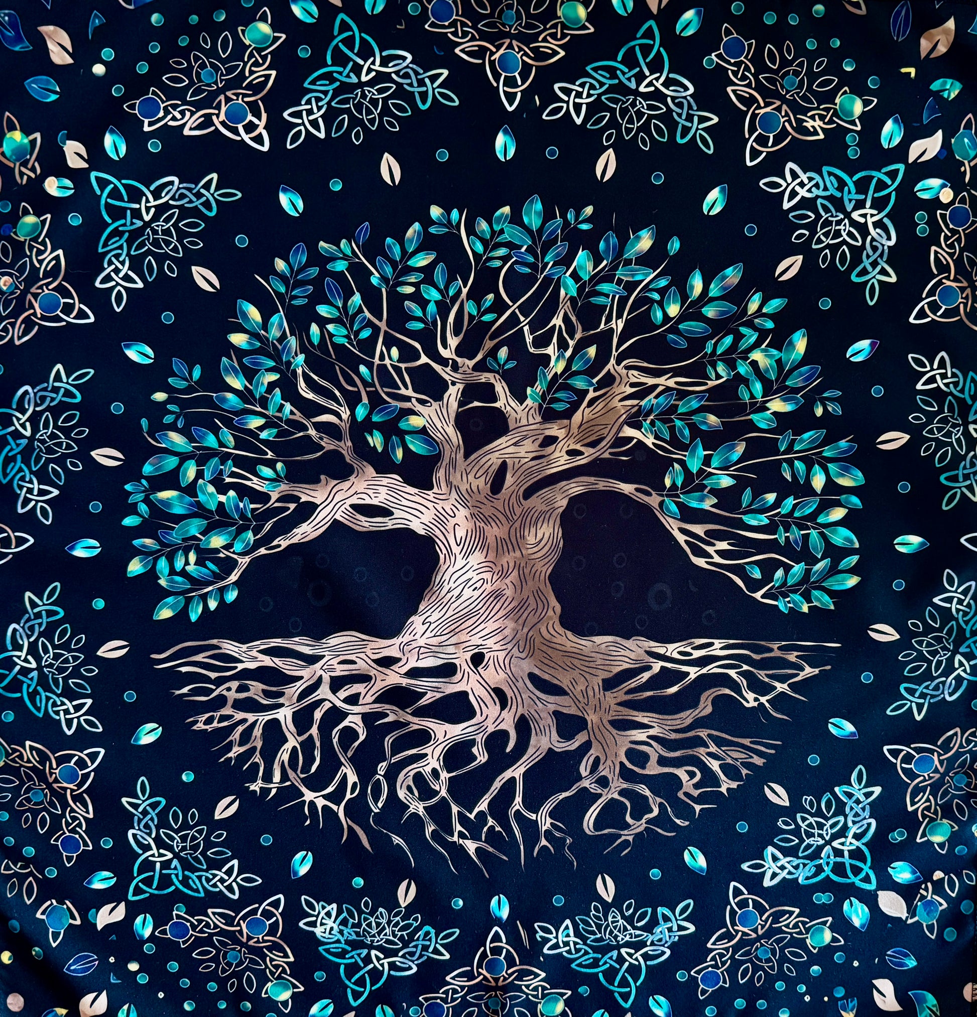Black fabric tapestry featuring a large tree with leaves and celtic knot designs.