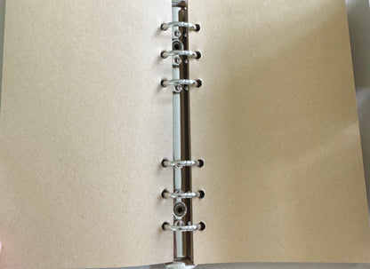 Open notebook with tan paper and metal rings.
