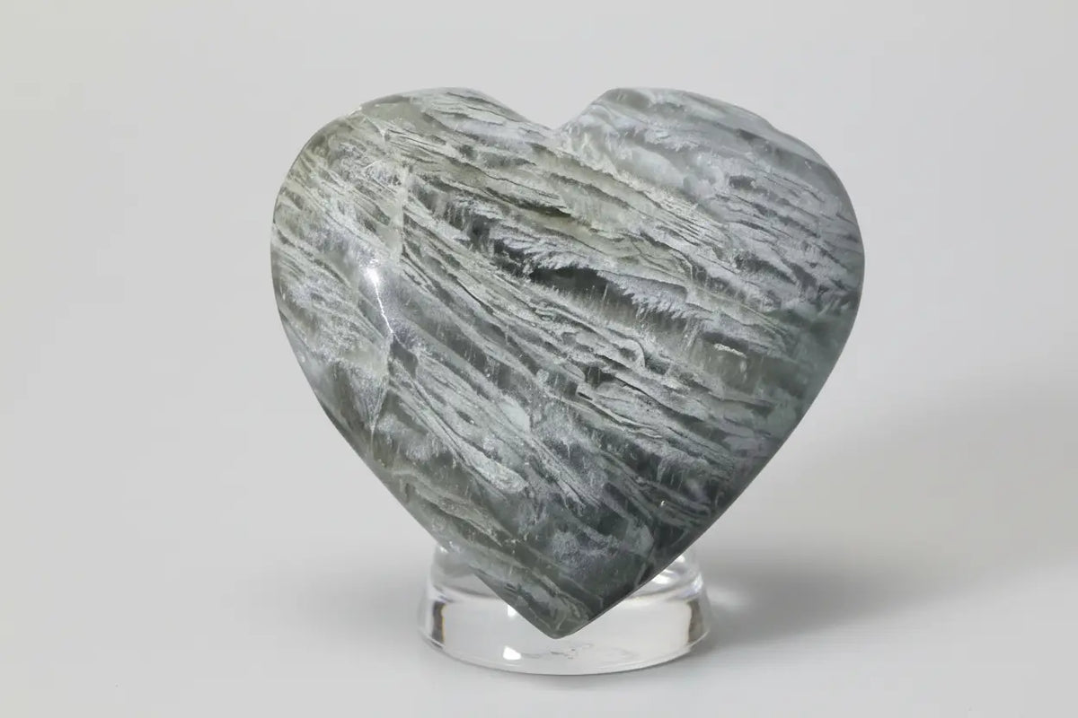 thousand layer garden quartz carved heart in a glass stand